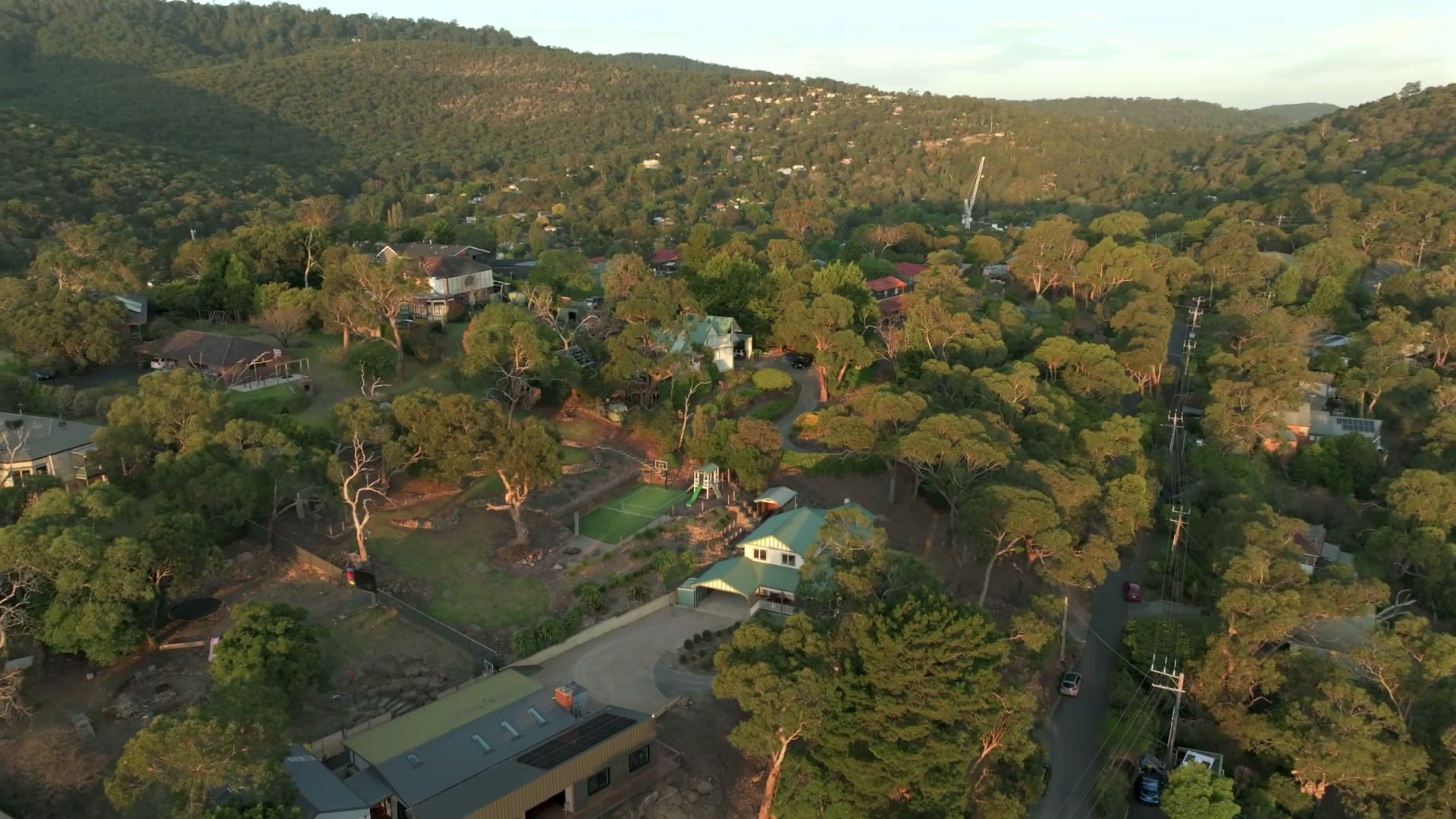 Aerial view at dusk over the leafy hillside streets of Upper Ferntree Gully