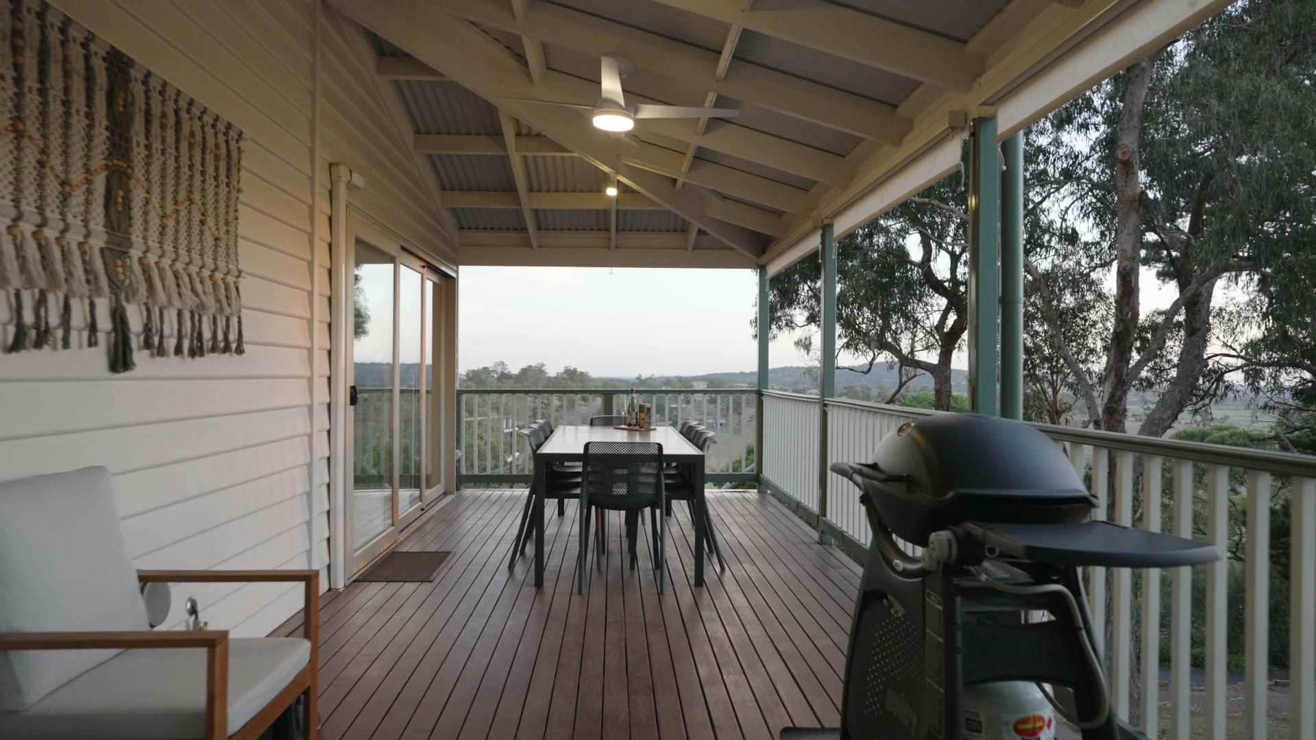 Covered timber deck with outdoor dining setting and bush views at 9 Fern Road
