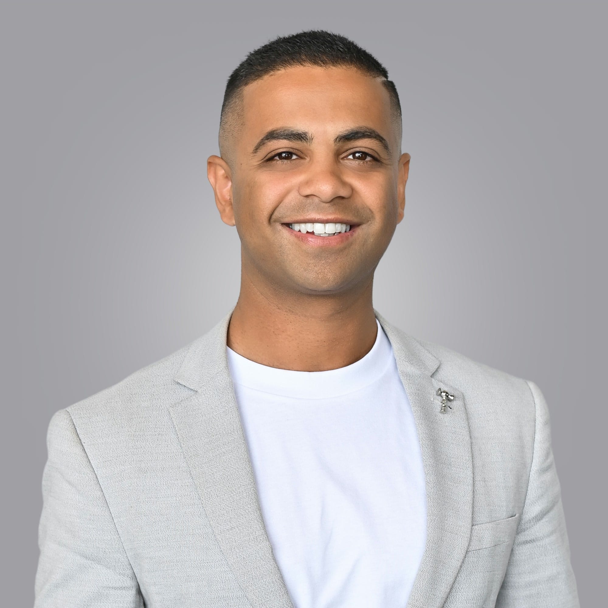 Studio portrait of Rohin Arora in a light grey blazer