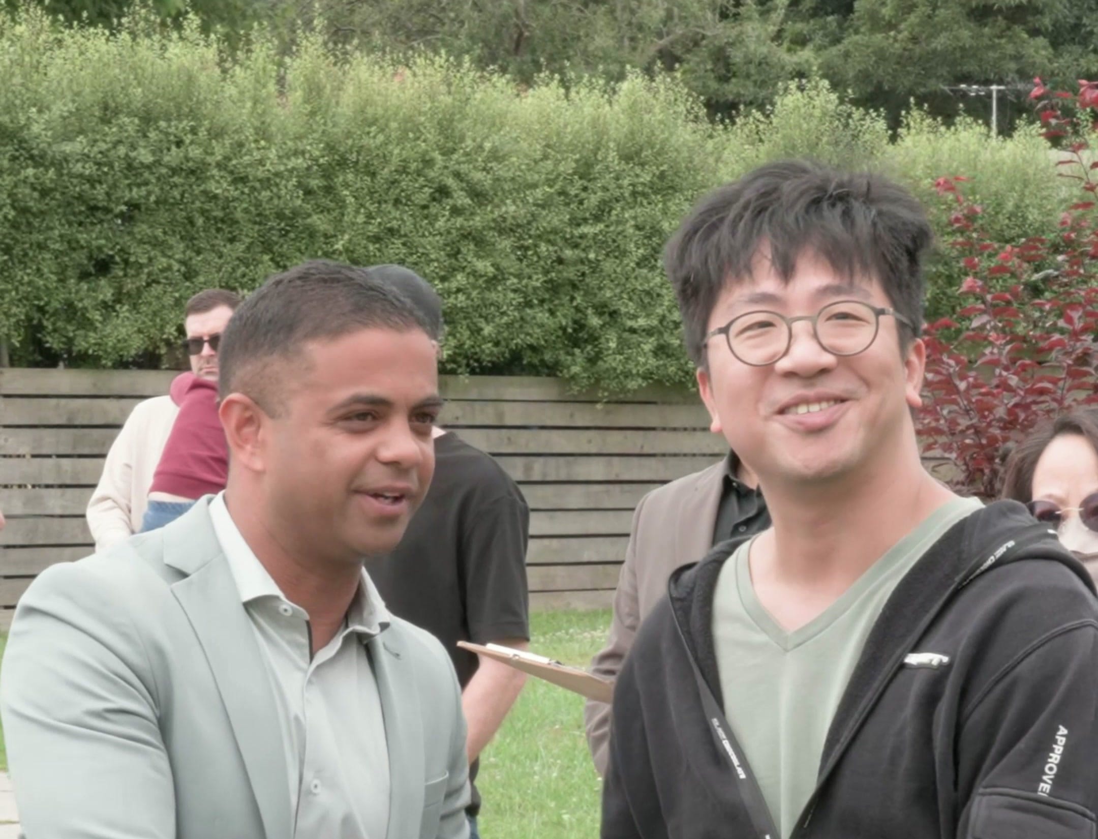 Rohin Arora greeting a guest on the footpath on auction day at 14 Willow Road, Upper Ferntree Gully